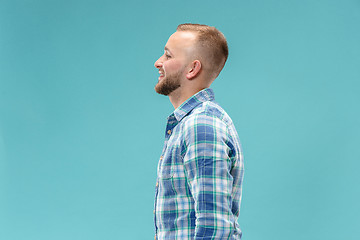 Image showing The happy business man standing and smiling against blue background.