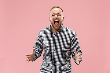 Image showing The young emotional angry man screaming on studio background