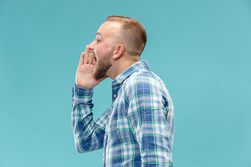 Image showing Isolated on pink young casual man shouting at studio