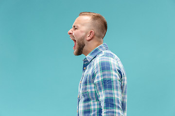 Image showing The young emotional angry man screaming on studio background