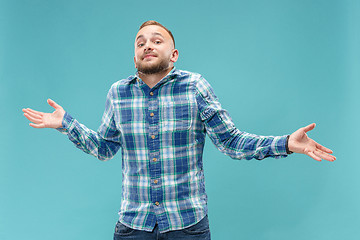 Image showing Beautiful man looking suprised and bewildered isolated on blue