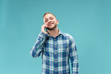 Image showing Young handsome man talking over phone and looking away.