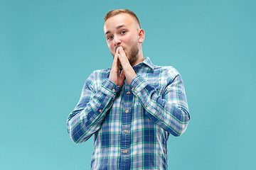 Image showing The young attractive man looking suprised isolated on blue