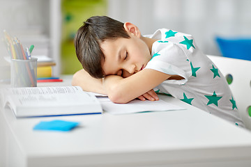 Image showing tired student boy sleeping on table at home