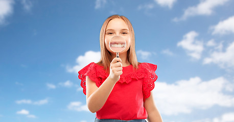 Image showing happy girl with magnifying glass over her teeth