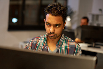 Image showing creative man with computer working at night office