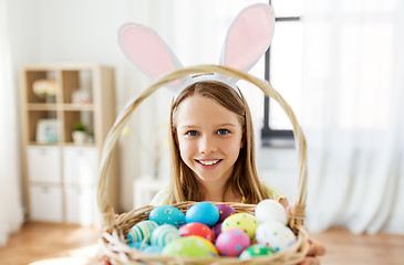 Image showing happy girl with colored easter eggs at home