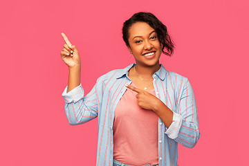 Image showing happy african american woman pointing finger up