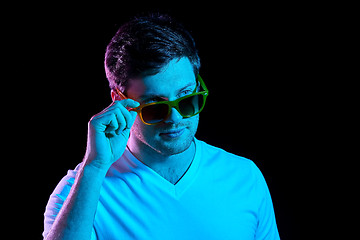 Image showing man in sunglasses over ultra violet neon lights