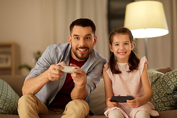 Image showing father and daughter playing video game at home