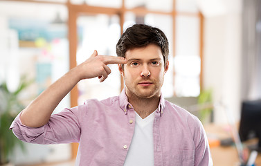 Image showing bored man shooting himself by finger gun gesture