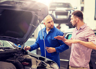 Image showing auto mechanic with clipboard and man at car shop