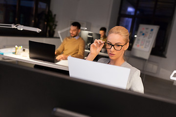 Image showing businesswoman with papers working at night office