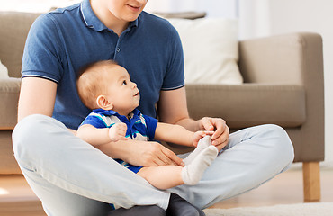 Image showing father with baby son sitting on floor at home