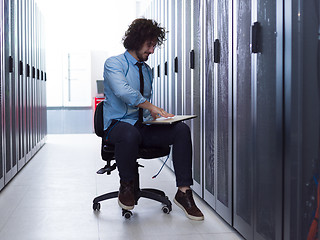 Image showing engineer working on a laptop in server room