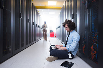 Image showing Team of young technicians working together on servers