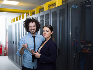 Image showing engineer showing working data center server room to female chief