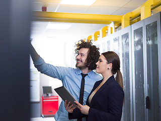 Image showing engineer showing working data center server room to female chief