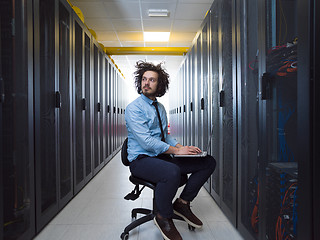 Image showing engineer working on a laptop in server room