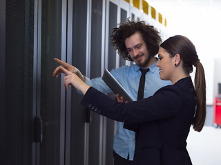 Image showing engineer showing working data center server room to female chief