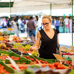 Image showing Woman buying fruits and vegetables at local food market. Market stall with variety of organic vegetable