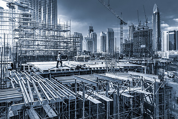 Image showing Laborers working on modern constraction site works in Dubai. Fast urban development consept