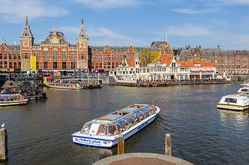 Image showing Tourists sightseeng at Canal Boats next tot Central Station of Amsterdam