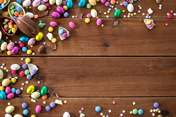 Image showing chocolate eggs and candy drops on wooden table