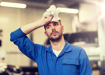 Image showing tired auto mechanic man or smith at car workshop