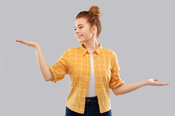 Image showing happy red haired teenage girl holding empty hands