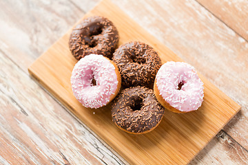 Image showing close up of glazed donuts pile on wooden board