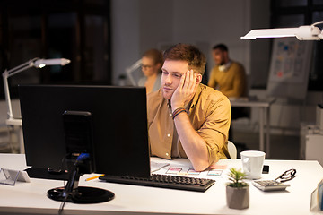 Image showing tired or bored man with computer at night office