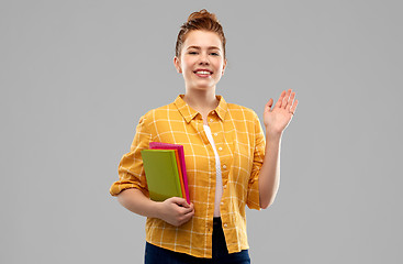 Image showing teenage student girl with books waving hand
