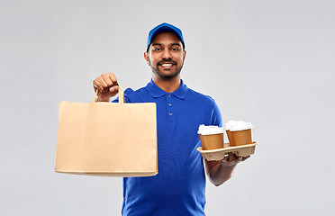 Image showing happy indian delivery man with food and drinks