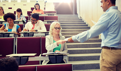 Image showing teacher giving exam tests to students at lecture