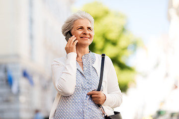 Image showing senior woman calling on smartphone in city