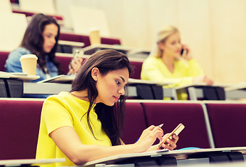 Image showing student girls with smartphones on lecture