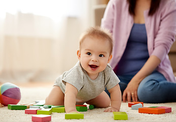 Image showing happy baby boy with toy blocks on carpet at home