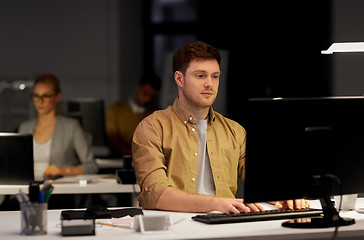 Image showing man with computer working late at night office