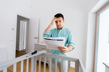 Image showing father with manual assembling baby bed at home