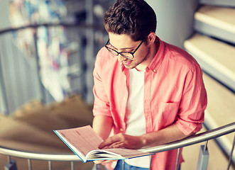 Image showing student boy or young man reading book at library