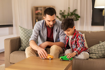 Image showing father and son playing with toy cars at home