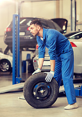 Image showing mechanic with wheel tire at car workshop