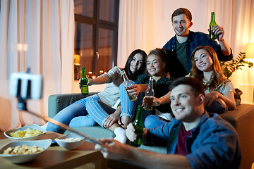 Image showing friends taking picture by selfie stick at home