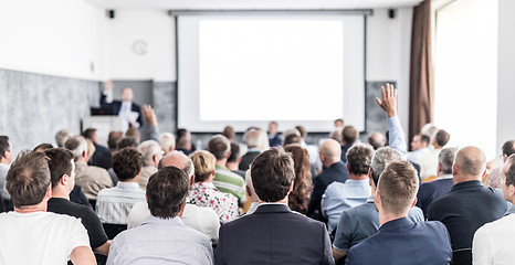 Image showing I have a question. Group of business people sitting in conference hall. Businessman raising his arm. Conference and Presentation. Business and Entrepreneurship