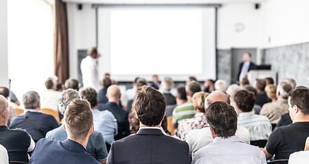 Image showing I have a question. Group of business people sitting in conference hall. Businessman raising his arm. Conference and Presentation. Business and Entrepreneurship