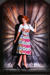 Image showing Portrait of a beautiful young woman in a dirndl, standing on a wooden wall.