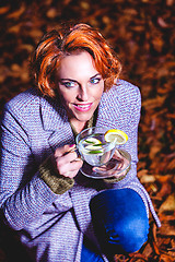 Image showing portrait of a smiling young woman drinking glass