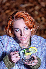 Image showing portrait of a smiling young woman drinking glass