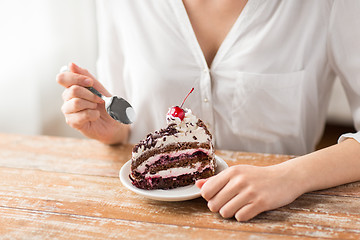 Image showing woman eating piece of layer cake with cherry